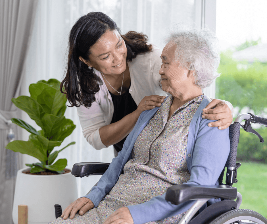 An elderly woman in a wheelchair talking to another woman.