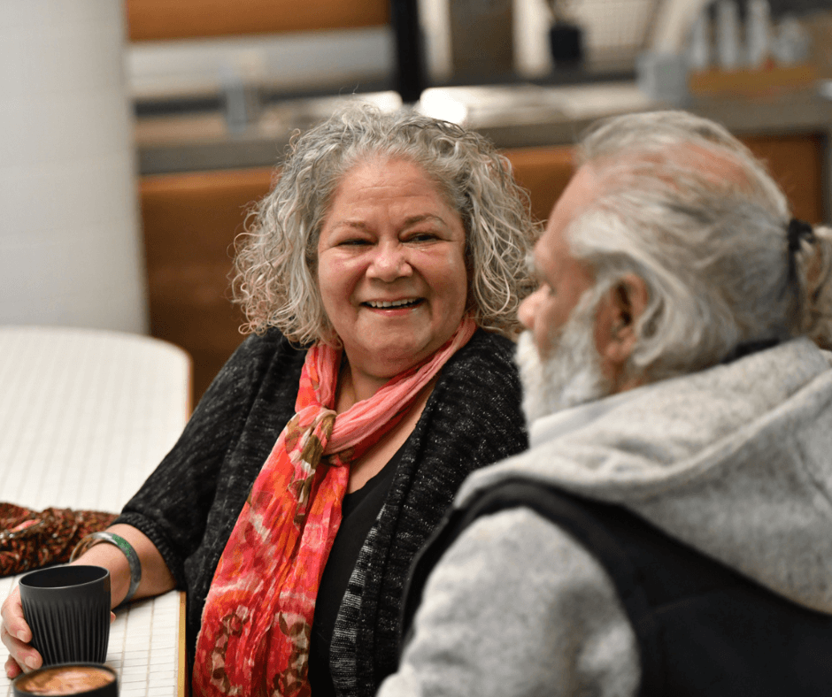 Two elderly people talking to each other.
