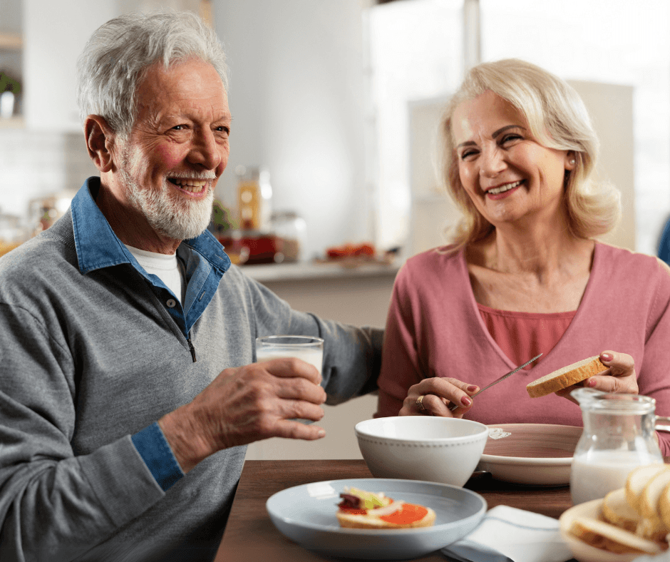 Elderly couple eating breakfast and talking.